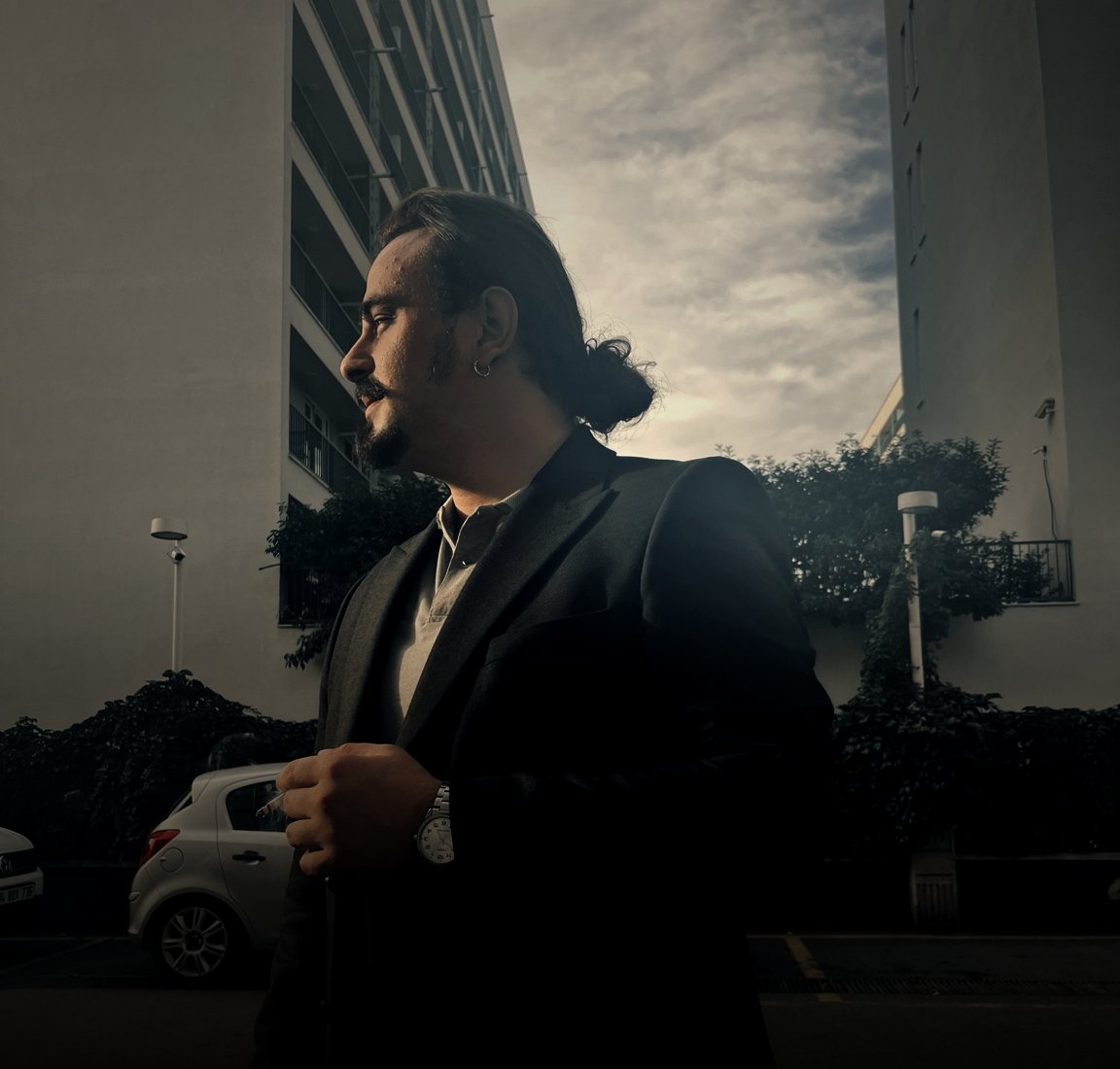 Doğan Özhan, profile against Istanbul high-rises at golden hour